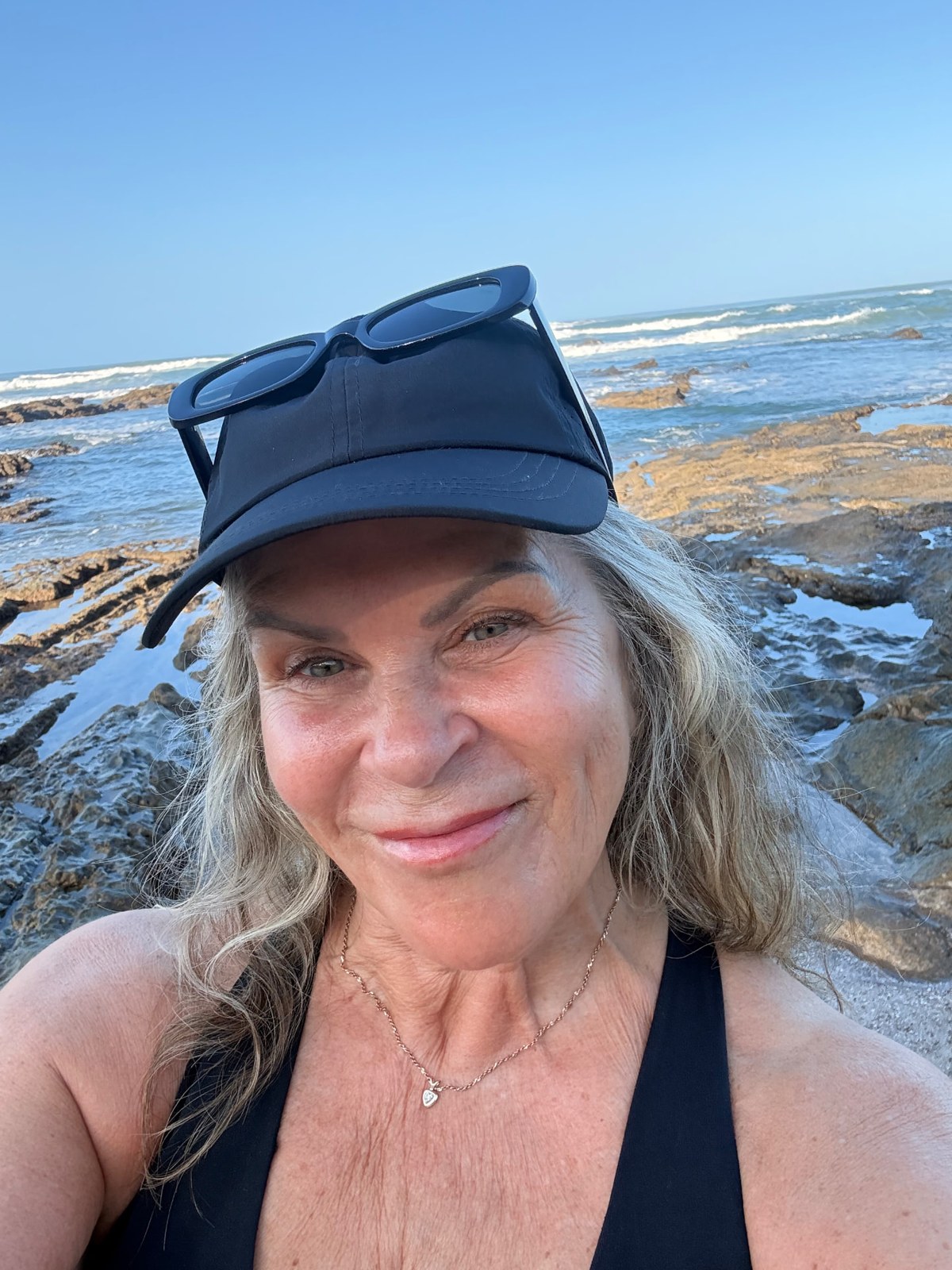 Lori smiling beside the ocean on a coastal walk